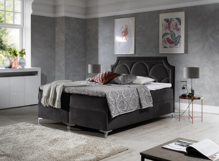 Modernes Boxspringbett in Anthrazit mit dekorativem Kopfteil im Schlafzimmer-Ambiente