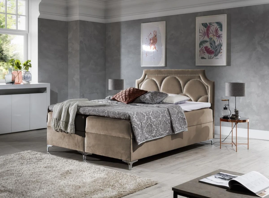 Elegantes Polsterbett in Taupe mit geschwungenem Kopfteil und Bettwäsche in Grau