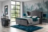 Graues Boxspringbett mit gestepptem Kopfteil in modernem Schlafzimmer mit Wald-Motivtapete.