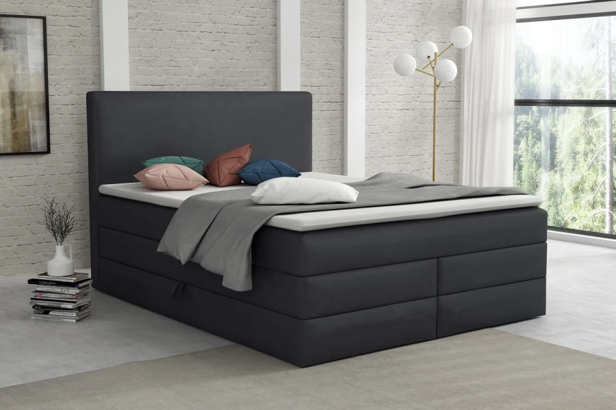 Dunkelgraues Boxspringbett in modernem Loft-Schlafzimmer mit weißer Backsteinwand und viel Licht.