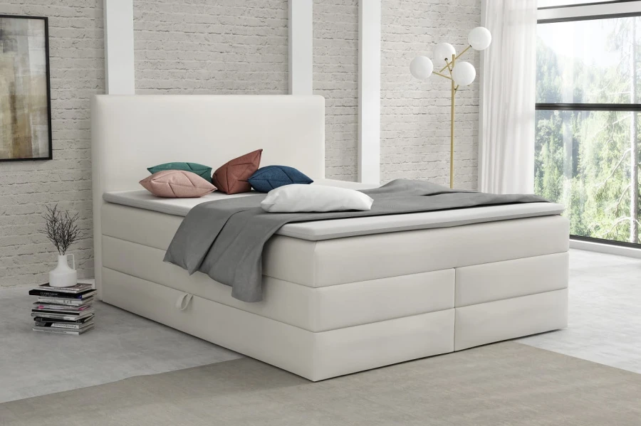 Modernes weißes Boxspringbett mit hohem Kopfteil im hellen Schlafzimmer