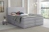Komfortables hellgraues Boxspringbett im zeitlosen Design für gemütliche Nächte.
