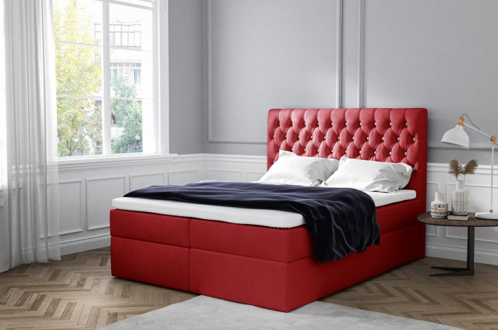 Elegantes rotes Boxspringbett mit gepolstertem Kopfteil im modernen Design.