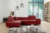 Modernes weinrotes Ecksofa aus Samt in einem hellen Wohnzimmer mit weißer Ziegelwand.