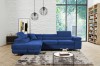 Elegantes blaues Samt-Ecksofa in einem stilvoll eingerichteten Wohnzimmer mit großen Fenstern.