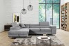 Hellgraues Ecksofa in modernem Wohnzimmer mit weißer Ziegelwand.