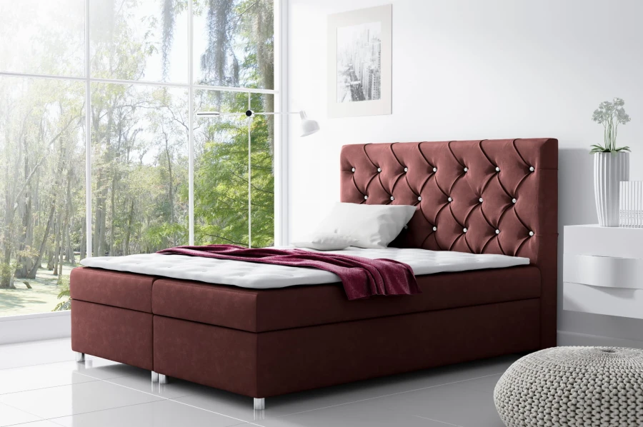 Bordeauxrotes Boxspringbett mit dekorativen Kristallen und komfortabler Matratze.
