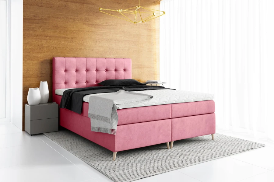 Rosa Boxspringbett mit gestepptem Kopfteil in modernem Schlafzimmer.
