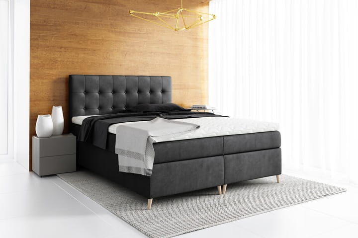 Anthrazitfarbenes Boxspringbett mit dekorativer Steppung im Schlafzimmer.