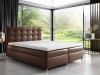 Braunes Boxspringbett mit gepolstertem Kopfteil in stilvoller Schlafzimmerumgebung.