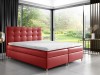 Rotes Boxspringbett als moderner Farbakzent im Schlafzimmer mit Blick in die Natur.