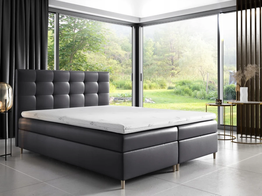 Anthrazitfarbenes Boxspringbett mit gestepptem Kopfteil in elegantem Design-Interieur.