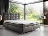 Graues Boxspringbett mit gestepptem Kopfteil in modernem Schlafzimmer mit Panoramablick.