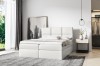 Weißes Boxspringbett im modern eingerichteten Schlafzimmer mit Teppich