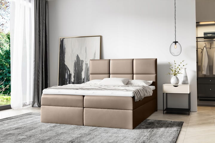 Elegantes beiges Boxspringbett in wohnlichem Schlafzimmer-Ambiente