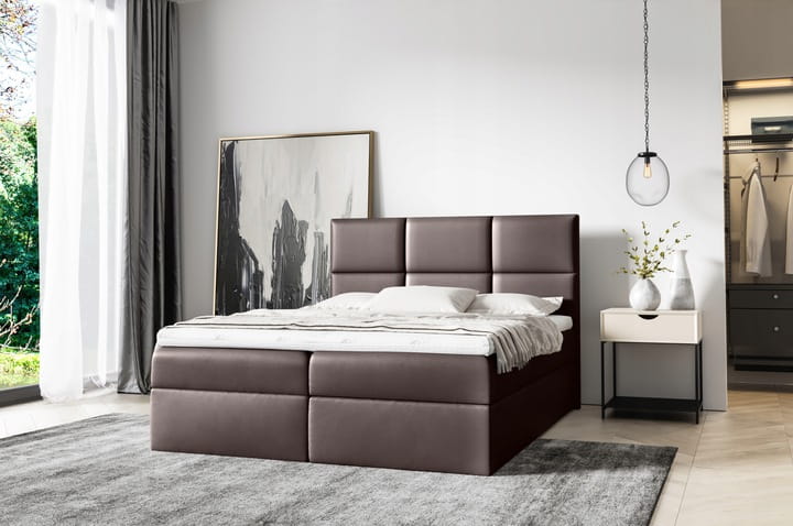 Braunes Boxspringbett mit gepolstertem Kopfteil in modernem Schlafzimmer-Design.