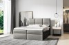 Graues Boxspringbett mit stilvoller Steppung in modern eingerichtetem Schlafzimmer.