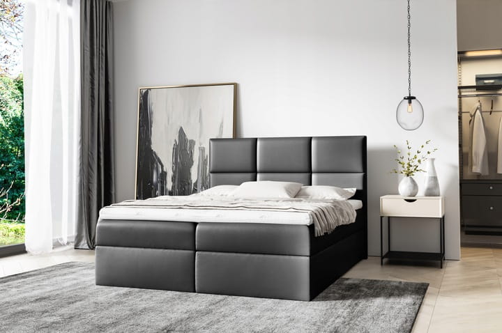 Schwarzes Boxspringbett aus hochwertigem Material in elegantem Schlafzimmer-Look.