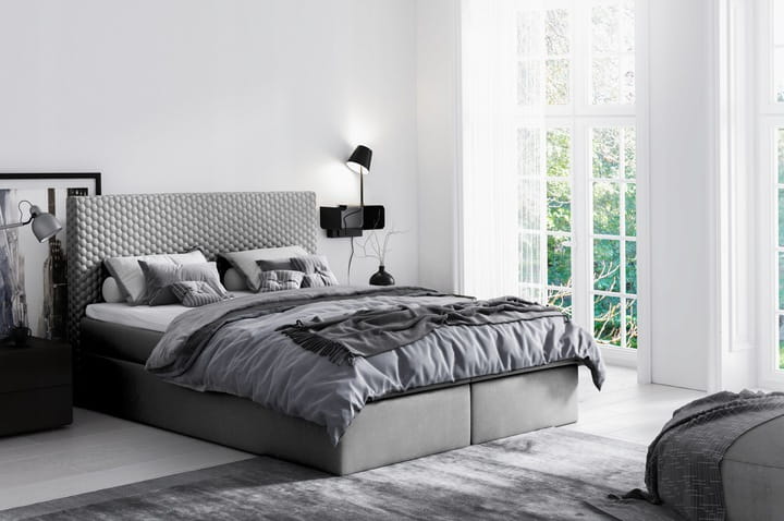 Modernes graues Polsterbett mit Waffelmuster-Kopfteil im hellen Schlafzimmer.