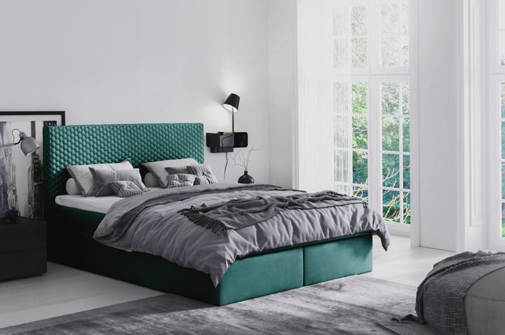 Smaragdgrünes Polsterbett mit gestepptem Kopfteil im Schlafzimmer-Ambiente.