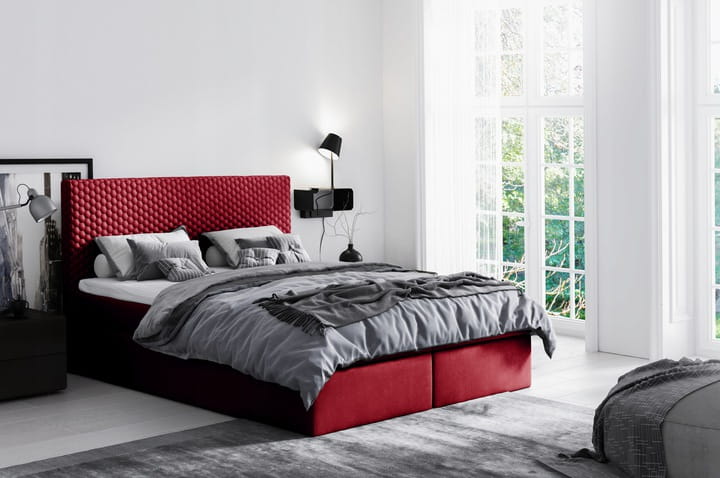 Modernes rotes Boxspringbett mit gestepptem Kopfteil im hellen Schlafzimmer.