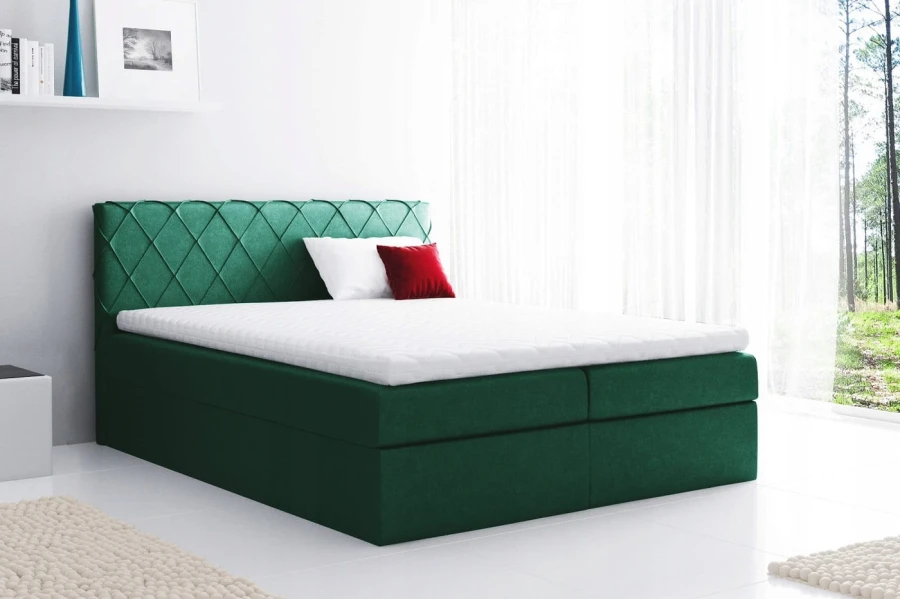 Dunkelgrünes Boxspringbett mit Rautenmuster am Kopfteil, inkl. Topper und Kissen.