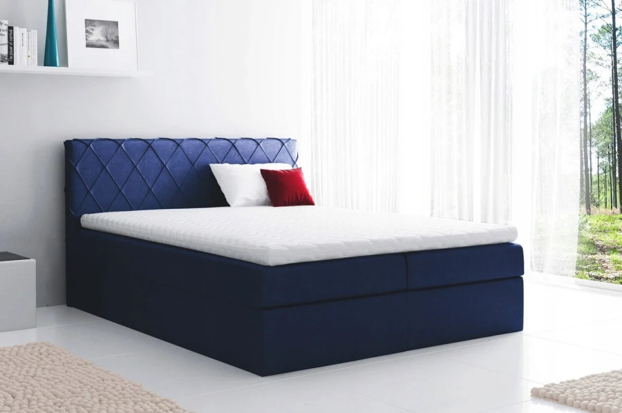 Dunkelblaues Boxspringbett mit Rauten-Steppung am Polsterkopfteil und gemütlichem Topper.