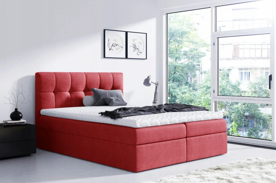 Elegantes rotes Boxspringbett mit gestepptem Kopfteil für ein stilvolles Schlafzimmer.