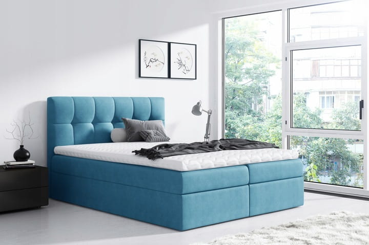 Türkisfarbenes Boxspringbett mit Polsterkopfteil als stilvoller Akzent im Schlafzimmer.