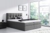 Modernes graues Boxspringbett mit gestepptem Kopfteil im hellen Schlafzimmer.