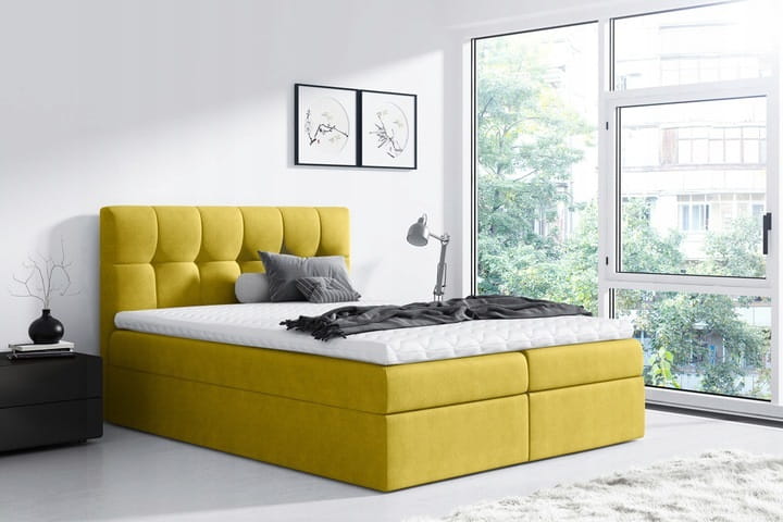 Modernes gelbes Boxspringbett in hellem Schlafzimmer mit gemütlicher Atmosphäre und großem Fenster.
