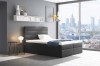 Schwarzes Boxspringbett in einem modernen Schlafzimmer mit beeindruckendem Blick auf die Skyline.