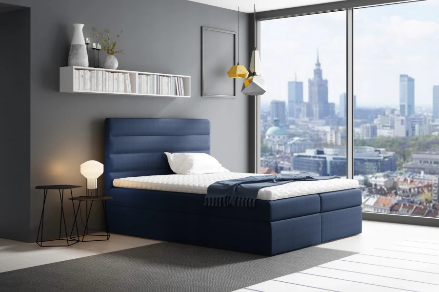 Dunkelblaues Boxspringbett mit gestreiftem Kopfteil in einem stilvoll eingerichteten Schlafzimmer.