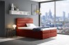 Rotes Boxspringbett als Farbakzent im Schlafzimmer mit hellem, modernem Ambiente.