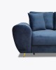 Detailansicht der geschwungenen Armlehne eines dunkelblauen Samtsofas mit goldenem Fuß.