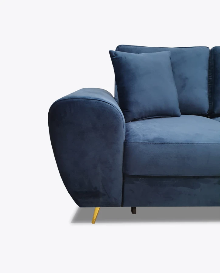 Detailansicht der geschwungenen Armlehne eines dunkelblauen Samtsofas mit goldenem Fuß.