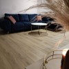 Blaues Ecksofa im hellen Wohnzimmer mit stilvollem Marmor-Couchtisch.
