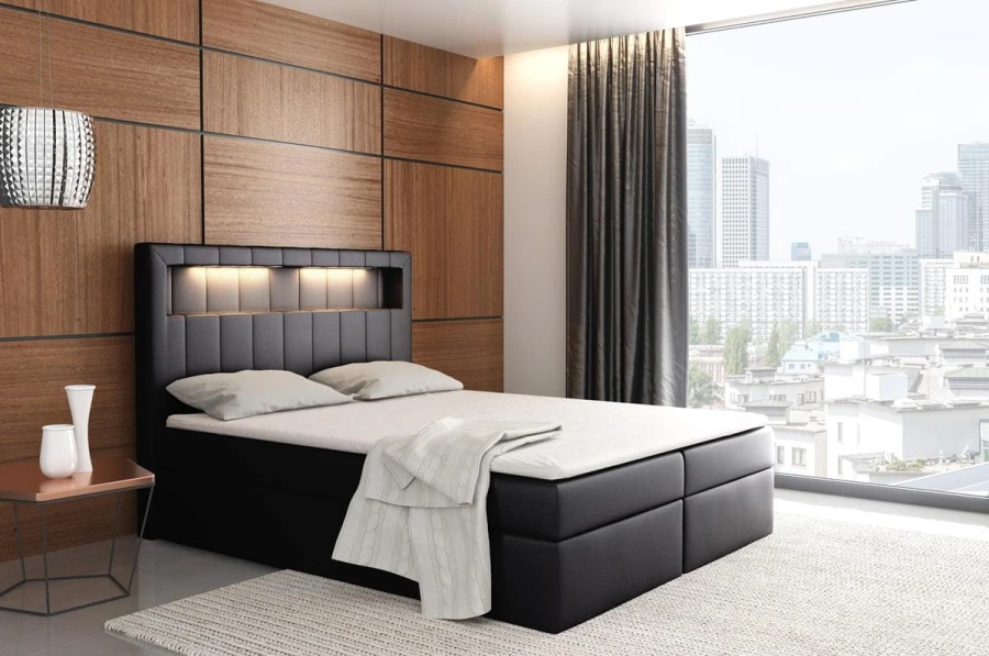 Schwarzes Boxspringbett mit LED-Beleuchtung im Kopfteil für ein modernes Schlafzimmer.