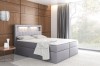 Graues Boxspringbett mit LED-Beleuchtung im Kopfteil, ideal für modernen Wohnstil.