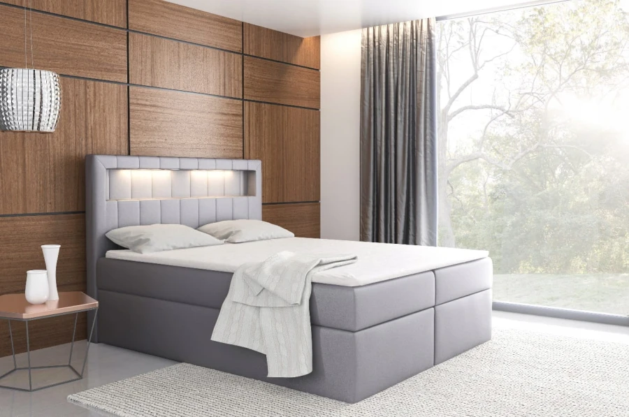 Graues Boxspringbett mit LED-Beleuchtung im Kopfteil, ideal für modernen Wohnstil.
