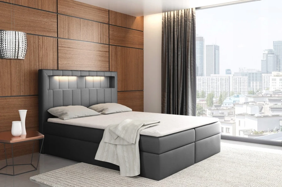Schwarzes Boxspringbett mit LED-Beleuchtung im Kopfteil vor Panoramafenster