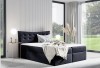 Dunkelblaues Boxspringbett aus Samt mit hohem Kopfteil in einem modernen, lichtdurchfluteten Zimmer.