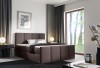 Dunkelbraunes Boxspringbett mit hohem Kopfteil in moderner Einrichtung.