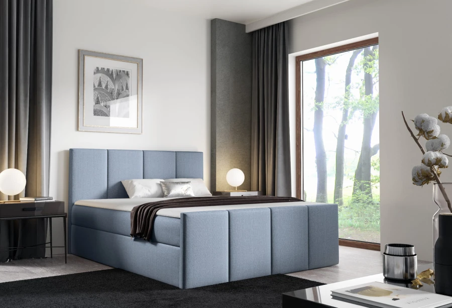 Modernes blaues Polsterbett im hellen Schlafzimmer mit Waldblick.