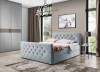 Hellblaues Boxspringbett mit Rautensteppung und Kristalldekor im eleganten Schlafzimmer.