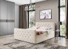 Cremefarbenes Boxspringbett mit Knopfheftung und Samt-Optik im stilvollen Schlafzimmer.