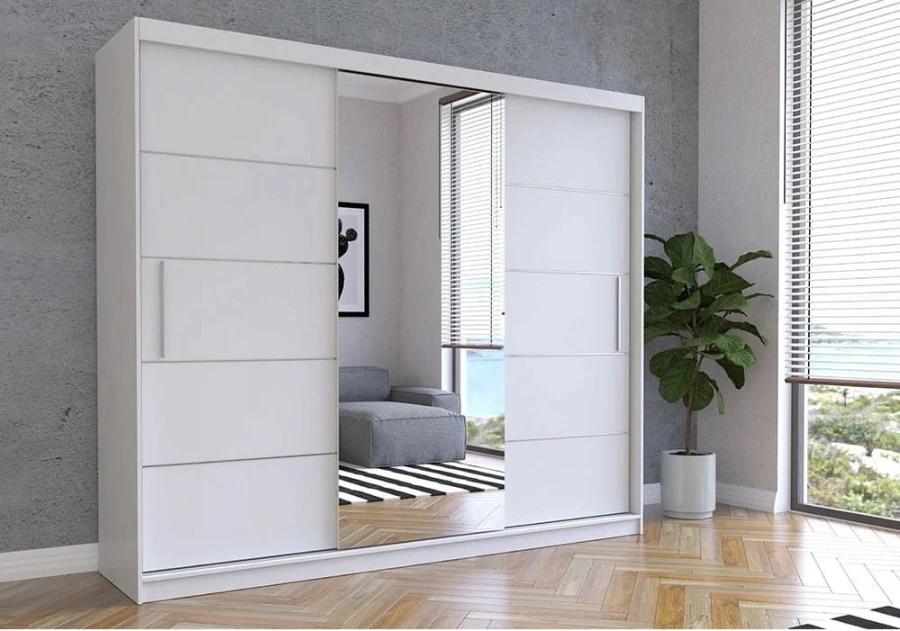 Großer Kleiderschrank in Weiß Matt mit Schiebetüren und Spiegel in einem hellen Wohnraum.
