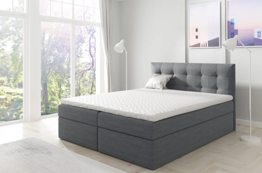 Modernes Boxspringbett in Dunkelgrau mit gestepptem Kopfteil.