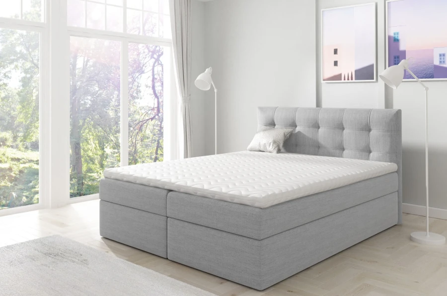 Stilvolles hellgraues Boxspringbett mit bequemer Matratze und Topper.