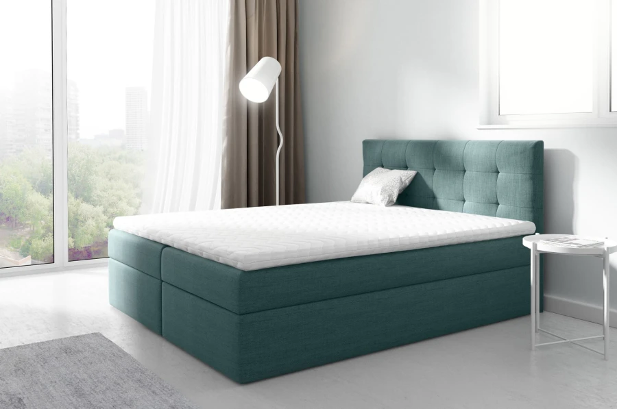Boxspringbett in Petrol mit weißem Topper und gepolstertem Kopfteil im Schlafzimmer